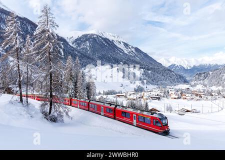 Berguen, Schweiz - 10. Januar 2024: Personenzug der Rhätischen Eisenbahn auf der Albula-Strecke in den Schweizer Alpen in Berguen, Schweiz. Stockfoto