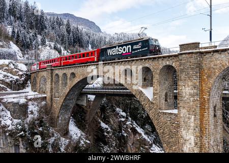 Solis, Schweiz - 10. Januar 2024: Personenzug der Rhätischen Bahn am Soliserviadukt auf der Albulalinie in den Schweizer Alpen in Solis, Schweiz. Stockfoto