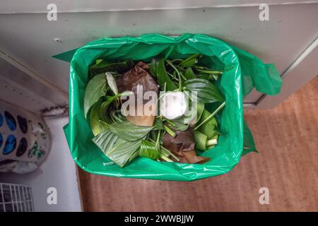 Essensreste in einem grünen Müllsack. Wird vom Müllwagen aufgenommen und verwandelt sich in Gas Stockfoto