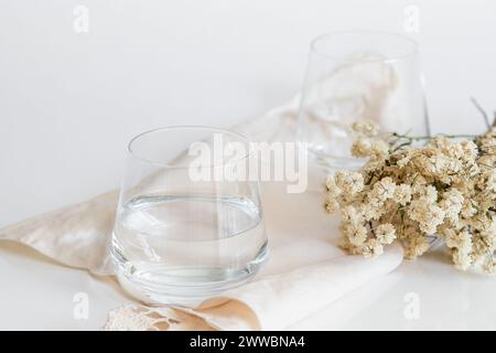 Glasbecher mit natürlichem Wasser auf weißem Hintergrund. Einfaches und sauberes Bild. Trinkwasser-Simplicity-Konzept. Stockfoto