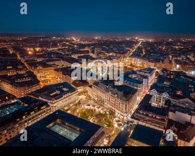 Nächtliche Stadtansicht über die Innenstadt von budapest. Inklusive Riesenrad, Erzsebet-Platz, Deak-Platz, Worosmarty-Platz. Blick auf die beleuchtete Straße Stockfoto