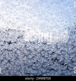 Frostiges Muster auf dem Glasfenster der Wohnwohnung in der Nähe am kalten Winterabend Stockfoto