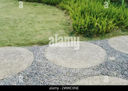 Gehweg und Busch. Das ist Betonpflaster, Boden, Weg, Fußweg, Weg oder Durchgang mit der Natur, um entlang zu gehen und verschiedene Sekten zu verbinden Stockfoto