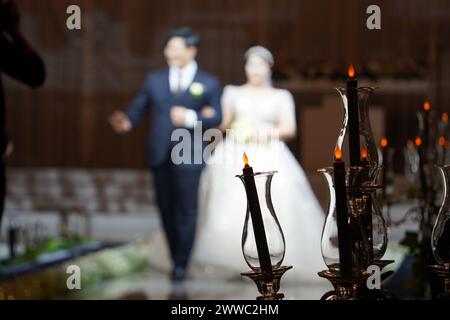 Hochzeitskerzen mit Braut und Bräutigam im Hintergrund Stockfoto