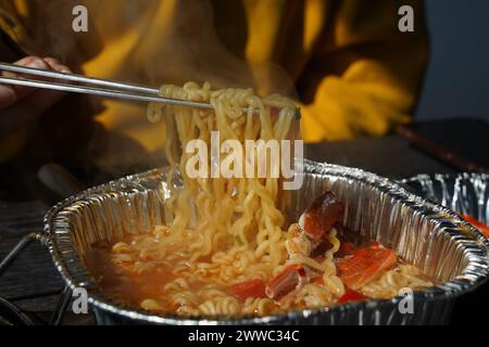 Instant-Ramen gekocht in einem Einwegbehälter aus Aluminium mit Meeresfrüchten wie Krabben Stockfoto