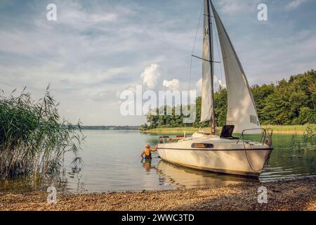 Frau, die auf einem Segelboot schwimmt Stockfoto