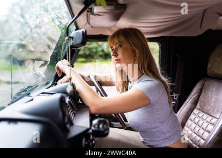 Besinnliche junge schöne Frau, die im Auto sitzt Stockfoto