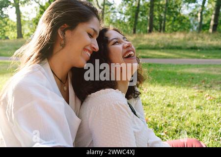 Fröhliche junge Freunde, die Spaß im Park haben Stockfoto