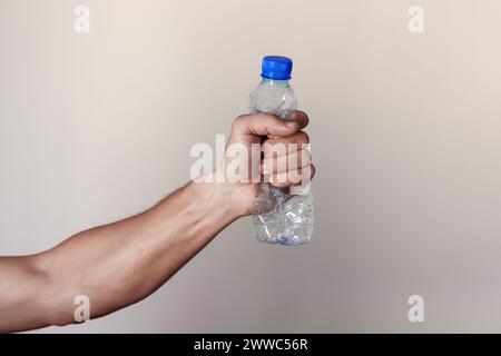 Kunststoffflasche mit Handdrücken, die Bewegung gegen Verschmutzung und Recycling darstellt Stockfoto