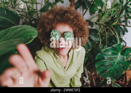 Glückliche Frau, die Hand greift und eine echeveria-Brille trägt Stockfoto