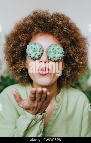 Eine Frau trägt eine echeveria-Blumenbrille und einen Kuss Stockfoto