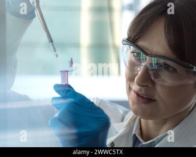 Wissenschaftler pipettieren der DNA-Probe in das eppendorf-Röhrchen im Labor Stockfoto