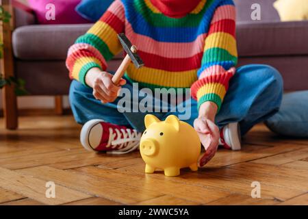 Frau, die zu Hause mit Hammer und Schweinebank sitzt Stockfoto