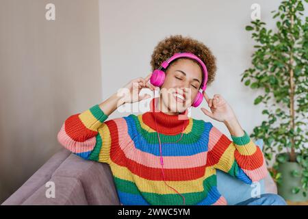 Lächelnde Frau Hören von Musik über Kopfhörer Stockfoto