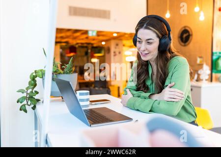 Lächelnde Geschäftsfrau mit Videokonferenz am Schreibtisch im Büro Stockfoto
