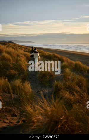 Junges Paar genießt die malerische Aussicht am Ozean Strand Stockfoto