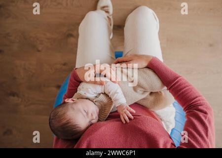 Mutter mit Tochter, die auf dem Schoß schläft Stockfoto