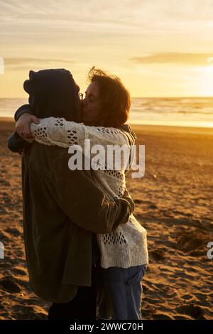 Liebevolles Paar, das sich am Strand küsst Stockfoto