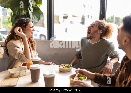 Verspielte Geschäftskollegen genießen die Mittagspause im Bürocafé Stockfoto