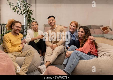 Glückliche Geschäftskollegen sitzen im Büro auf Sitzsäcken Stockfoto