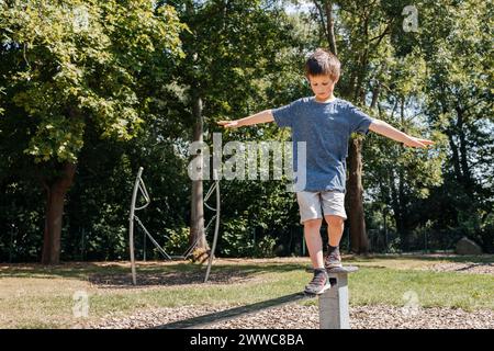 Junge balanciert auf Metallstruktur auf dem Spielplatz Stockfoto