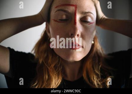 Depressive Frau mit Kopf in den Händen vor grauem Hintergrund Stockfoto