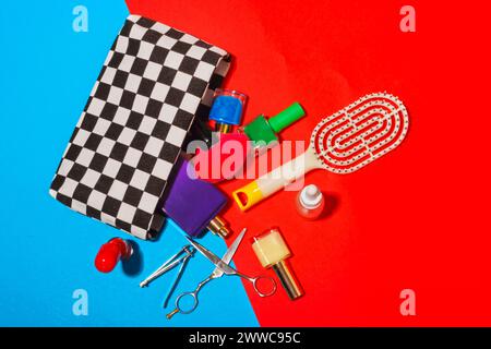 Studio-Aufnahme von verschiedenen Kosmetikartikeln, die aus der karierten Tasche fallen Stockfoto