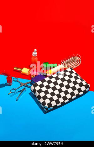 Studio-Aufnahme von verschiedenen Kosmetikartikeln, die aus der karierten Tasche fallen Stockfoto