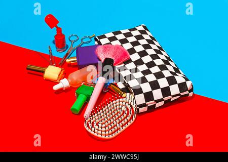 Studio-Aufnahme von verschiedenen Kosmetikartikeln, die aus der karierten Tasche fallen Stockfoto