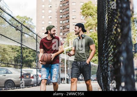 Junge Freunde reden und gehen auf Fußweg Stockfoto