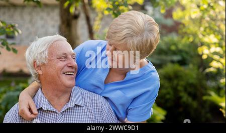 Glücklicher älterer Mann, der Freizeit mit Frau im Garten verbringt Stockfoto