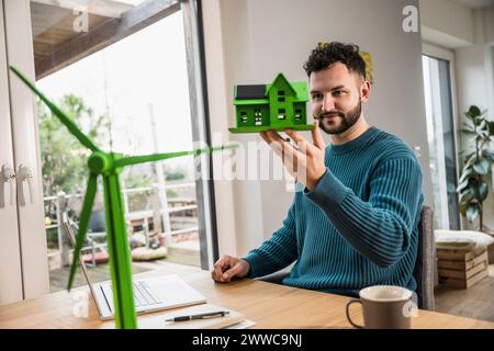 Architekt untersucht Modellhaus am Schreibtisch Stockfoto