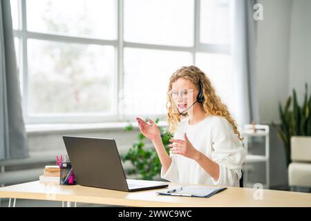 Lächelnder Kundendienstmitarbeiter, der im Büro bei Videoanrufen spricht Stockfoto