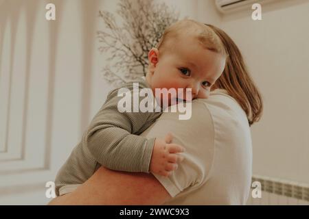 Ein Kleinkind in den Armen der Mutter zu Hause Stockfoto