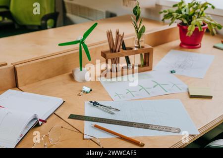 Schreibtisch mit Entwurf für Windkraftanlage und Modell im Büro Stockfoto