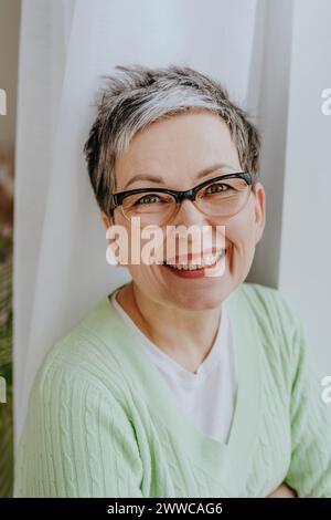 Glückliche Frau mit Brille zu Hause Stockfoto