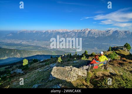 Österreich, Tirol, zwei Wanderer, die auf einer Bergbank eine Pause machen Stockfoto