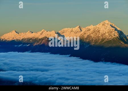 Österreich, Tirol, Alpenglow über nebelbedeckten Tal bei Sonnenaufgang Stockfoto