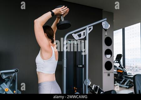 Reife Frau, die Hantel im Fitnessstudio hebt Stockfoto
