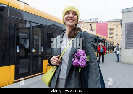 Glückliche Frau, die am Bahnsteig in der Nähe des Zuges steht Stockfoto