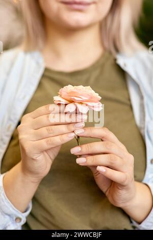 Frau, die Rosenblume in den Händen hält Stockfoto