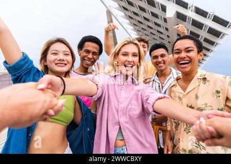 Glückliche junge Freunde, die Hände halten und Spaß haben Stockfoto