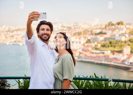 Ein lächelnder junger Mann macht Selfie mit der Frau über das Smartphone Stockfoto