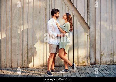 Liebevolles junges Paar, das vor der Wand steht Stockfoto