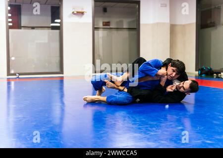 Athleten, die beim Jujitsu-Training im Dojo wrestlen Stockfoto