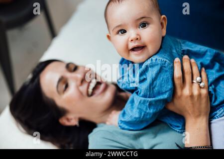 Verspielte Tochter mit glücklicher Mutter im Bett Stockfoto