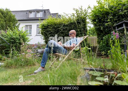 Freiberuflicher Mitarbeiter, der im Garten am Laptop arbeitet Stockfoto