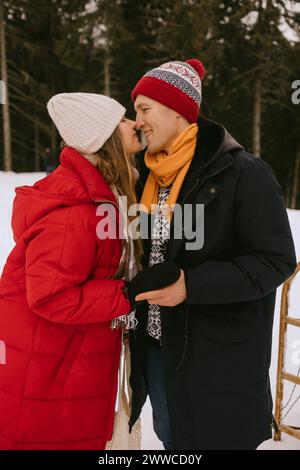 Liebevolles Paar, das Hände im Winterwald hält Stockfoto