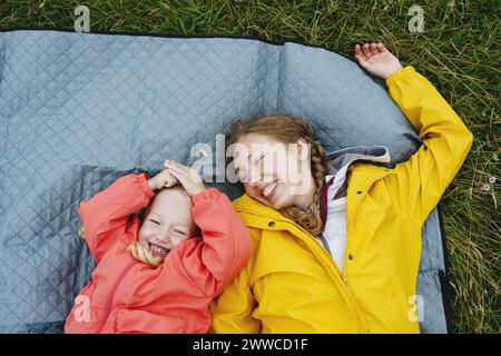 Glückliche Mutter und Tochter liegen auf Picknickdecke Stockfoto