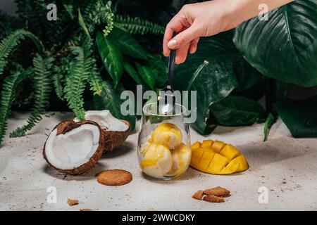 Die Hand einer Frau isst Eis aus Glas Stockfoto